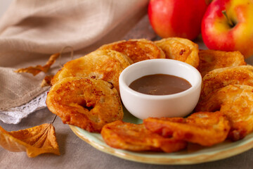 Apples in the dough on a table with caramel sauce