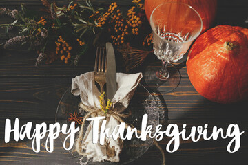 Happy thanksgiving text on plate, cutlery,  napkin on wooden table with pumpkins and autumn...