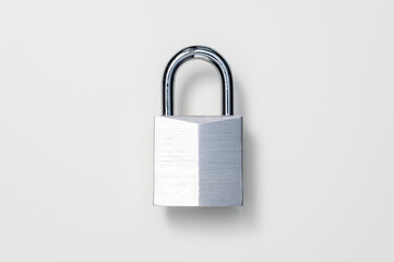 Security, lock or theft protection concept. Shiny, nickel-plated solid brass padlock against white...