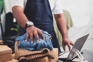 Male business owner selling products online at home with packaging boxes preparing to deliver products to customers lifestyle concept.
