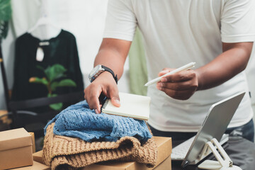 Fototapeta premium Male business owner selling products online at home with packaging boxes preparing to deliver products to customers lifestyle concept. 