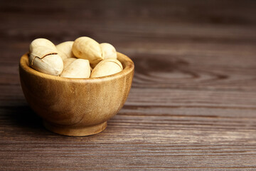 Pecan nuts in bowl on wooden table