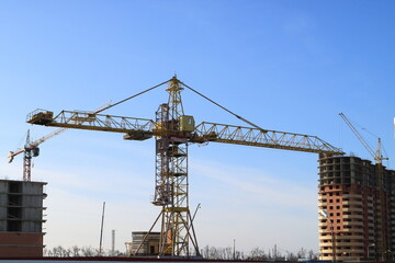 Fototapeta na wymiar Tower cranes are working on the construction of a new house. Lifting crane.