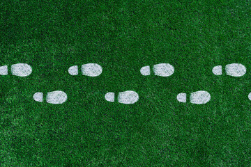 White boot prints on the green grass.Football field
