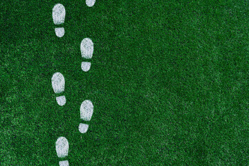 White boot prints on the green grass