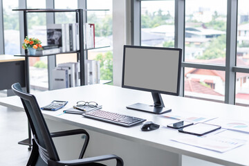 Workspace Business mockup desktop computer empty black gray screen with keyboard notebook and other accessories on Modern dark wooden office corner and black office chairs with window in office