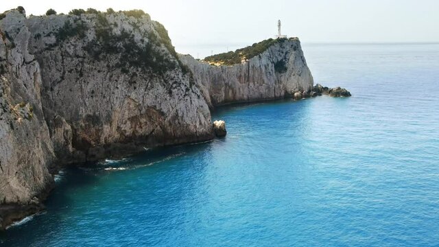 Aerial drone view of the Ionian Sea coast of Zakynthos, Greece. Rocky ridge with lighthouse and sparce vegetation, blue water