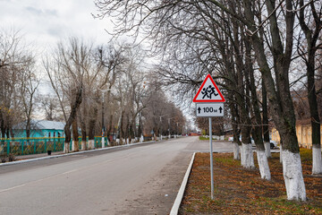 Road sign: "careful children", near the educational institution. A warning road sign obliging you to be careful on the road, next to an educational institution.
