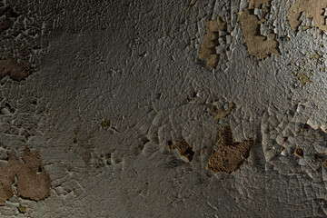 The texture of cracked paint on the wall of an old crumbling building. The textured wall of a very old abandoned house.