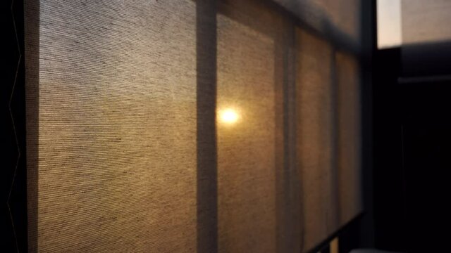 Opening closing roller blind curtain on a frozen balcony window, sun shines through the window shade in cold season. High quality 4k footage