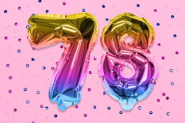 Rainbow foil balloon number, digit seventy eight on a pink background with sequins. Birthday greeting card with inscription 78. Top view. Numerical digit. Celebration event, template.