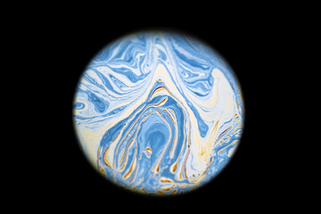 Multicolor psychedelic abstract round blue planet in universe. Closeup soap bubble like an alien planet on dark background