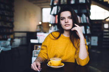 Young woman with cup of coffee in cafe