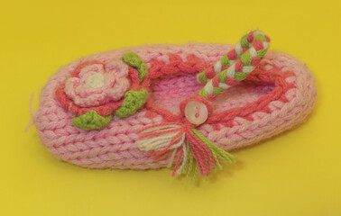 A pink children's wool sock on yellow background