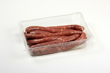 Plastic package with raw uncooked sausages. sausages in a plastic packaging tray