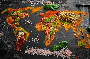 Fototapeten Gewürzbanner. Die Weltkarte besteht aus verschiedenen Gewürzen und Gewürzen auf dunklem Hintergrund. Ansicht von oben. © Yaruniv-Studio