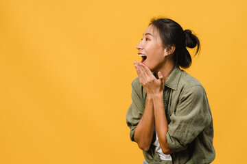 Young Asia lady feel happiness with positive expression, joyful surprise funky, dressed in casual cloth isolated on yellow background. Happy adorable glad woman rejoices success. Facial expression. - obrazy, fototapety, plakaty
