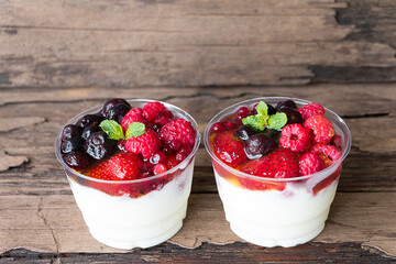 Fruit yogurt has strawberry raspberry blueberry canberry and honey greek white clean In bowl on a wooden background from top view.
