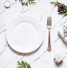 Christmas or New Year table settings on the marble texture table with festive decoration. Top view. Copy space 