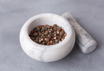 Spices in a mortar, stone mortar, and pestle, cooking tool on gray background.