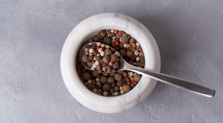 Spices in a mortar, stone mortar, and pestle, cooking tool on gray background.