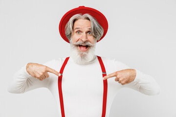 Elderly gray-haired mustache bearded man 50s in turtleneck red hat suspenders point index finger on...