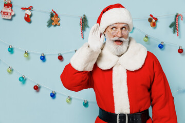 Old bearded Santa Claus man 50s wears Christmas hat red suit try hear you overhear listening...