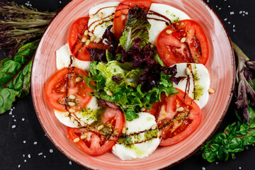 Caprese Salad - Salad with Tomatoes, Mozzarella Cheese, Basil, Asparagus and Balsamic. Salad Dressing with Pesto Sauce