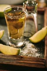 Shots of tequila with slices of lime and salt