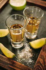 Shots of tequila with slices of lime and salt