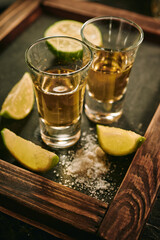 Shots of tequila with slices of lime and salt