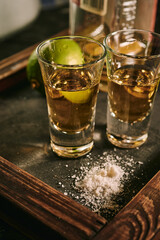 Shots of tequila with slices of lime and salt