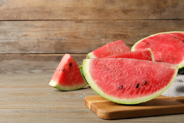 Delicious fresh watermelon slices on wooden table. Space for text