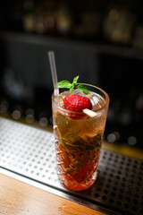 Low angle closeup of a gourmet mixed drink cocktail of sweet pink lemonade on a steel bar