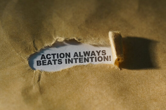 Torn paper in the middle of the sheet, inside on a white background the inscription - ACTION ALWAYS BEATS INTENTION