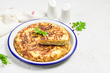 Spanish tortilla, potato onion omelette on light background. Space for text.
