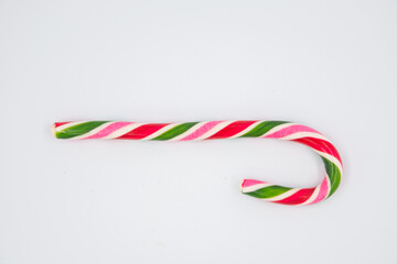 Festive Christmas treat. Flat lay of striped red candy cane isolated on white background. Copy space.