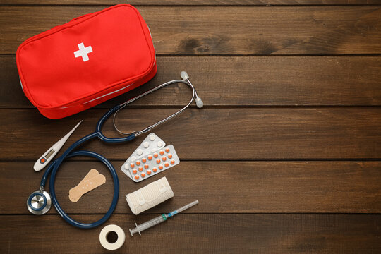 First aid kit on wooden table, flat lay. Space for text