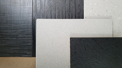 close up combination of grainy artificial stone samples in brown, grey color and black melamine...