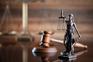 Law symbols composition on brown background. Gavel, scale and Themis sculpture. Place for text.