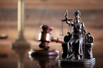 Law symbols composition on brown background. Gavel, scale and Themis sculpture. Place for text.