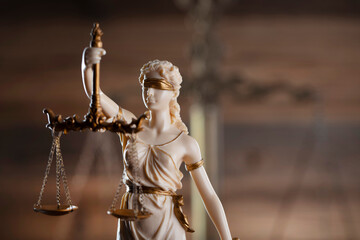 Law symbols composition on brown background. Gavel, scale and Themis sculpture. Place for text.