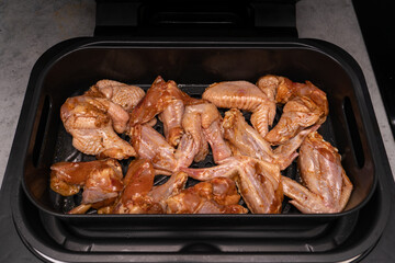 Chicken wings in an air fryer bowl for quick healthy home cooking