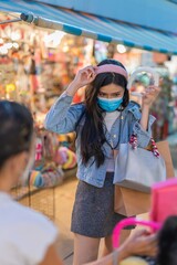 Obraz na płótnie Canvas Asian woman shopping in a random night market in Bangkok, Thailand 