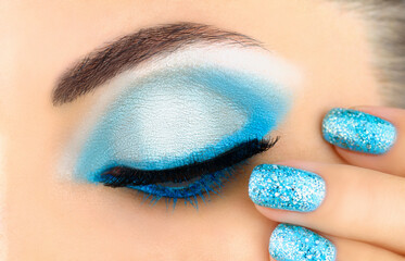 Beautiful luxurious makeup and manicure. Makeup in blue shiny tones. Festive manicure and eye makeup.
