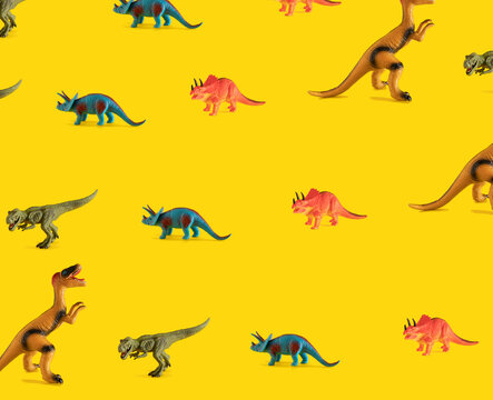 pattern made with dinosaur toy against yellow illuminating background. surreal modern abstract art