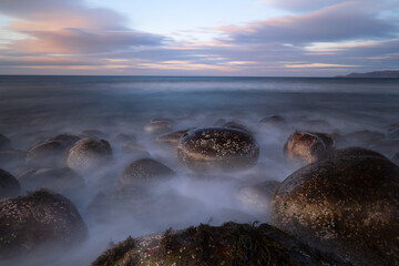 Sunset on the ocean with mystical fog in the foreground