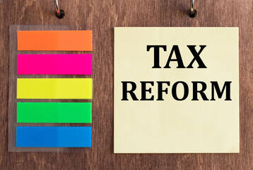 Tax Reform on a yellow sticker on a wooden background. Business concept for Government Change in Taxes written on sticky note paper on the wooden background.