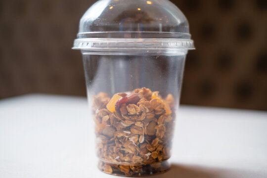Muesli in a transparent plastic container. Healthy takeaway granola food.