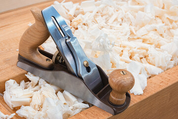 Wooden hand plane for woodworking with wood shavings.